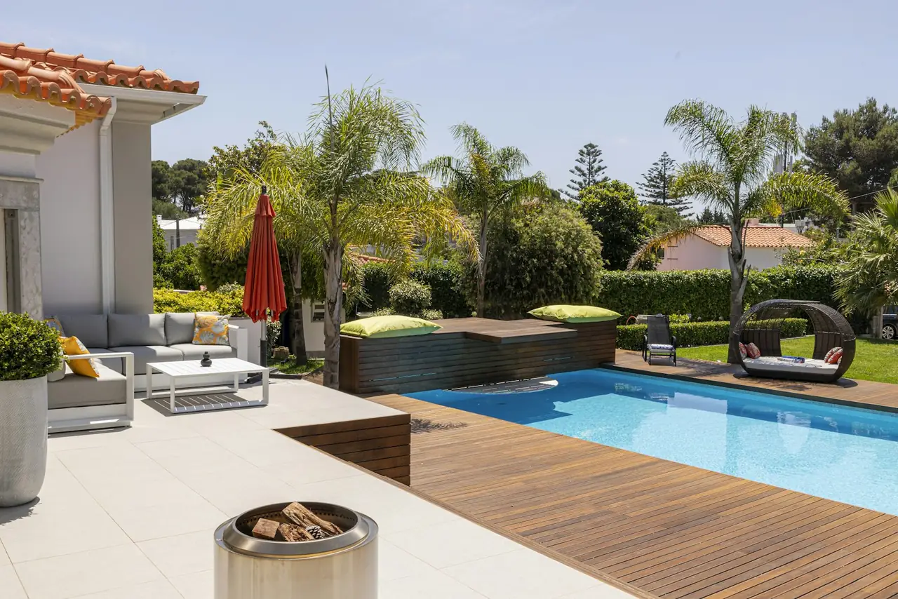 Clear pool beside a timber deck and outdoor lounge