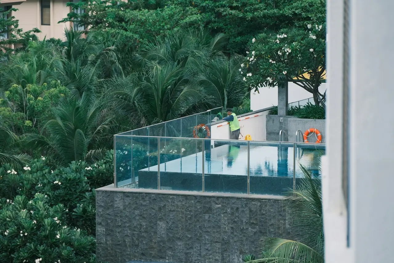 Glass-fenced plunge pool surrounded by greenery