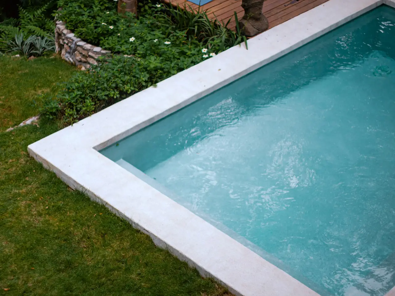Concrete pool edged by green lawn